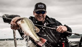 Angler wearing a Strike King hat pulling a fish out of the water